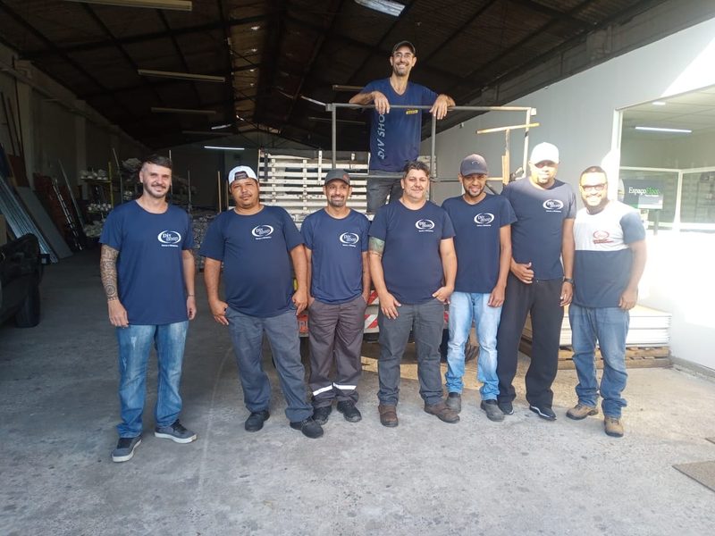 Equipe da DivShop reunida no galpão, de uniforme